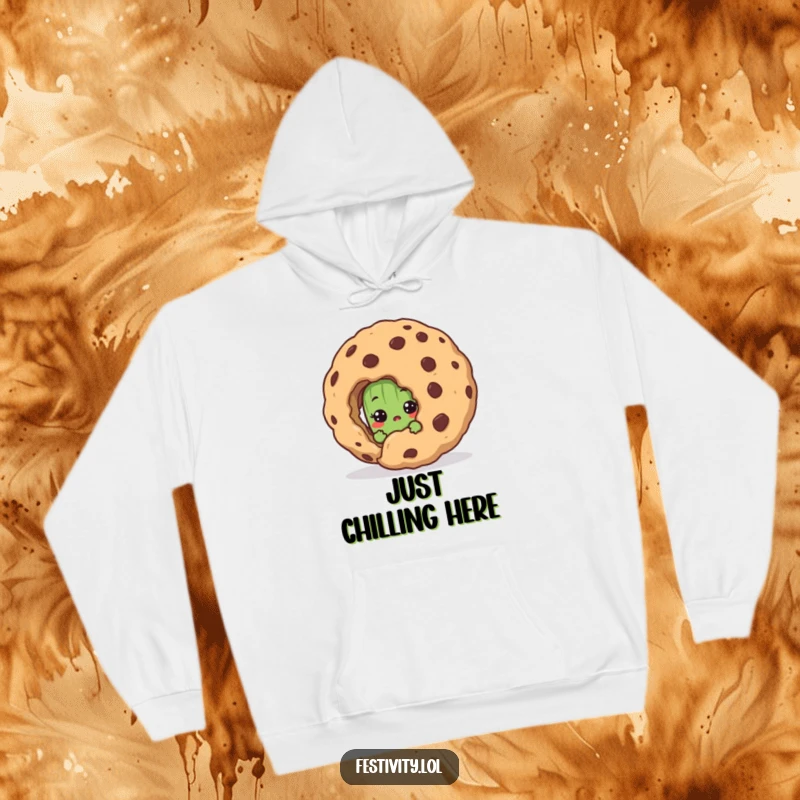 Funny hoodie depicting a shy pickle peeking with surprised eyes behind a gigantic cookie, perfect for cold days and smiles.