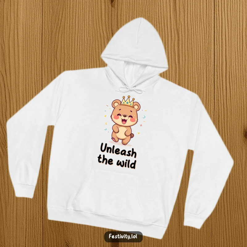 Funny hoodie with a giggling bear cub wearing a streamer crown, dancing with pure delight, ideal for cozy fun.