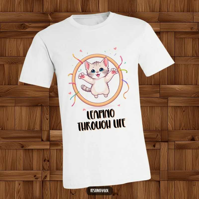 Funny t-shirt depicting a curious kitten mid-air, leaping through a giant hoop with streamers.